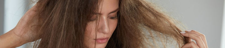 woman looks at damaged hair